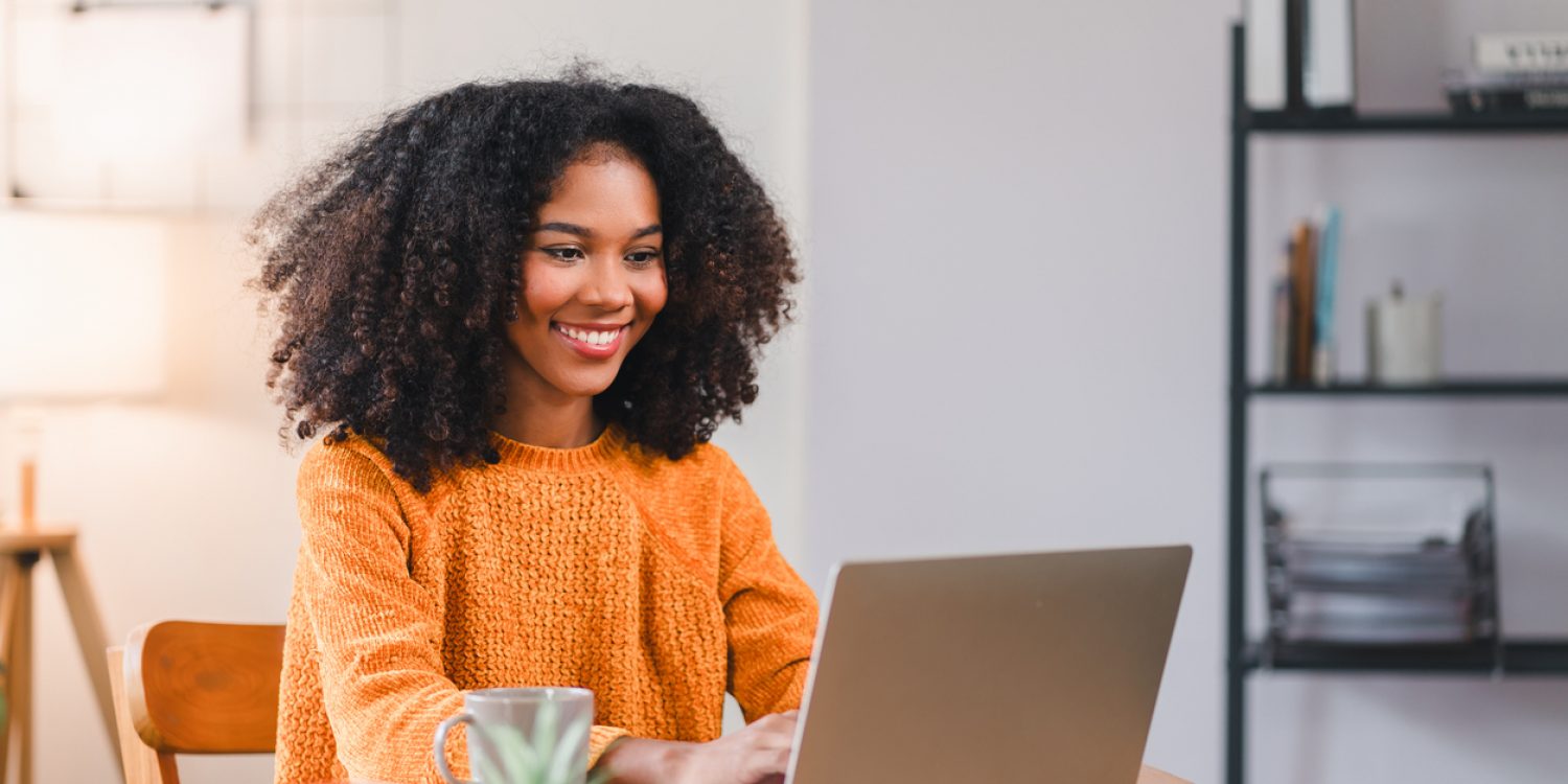 Smiling African American woman using a laptop while working from home
