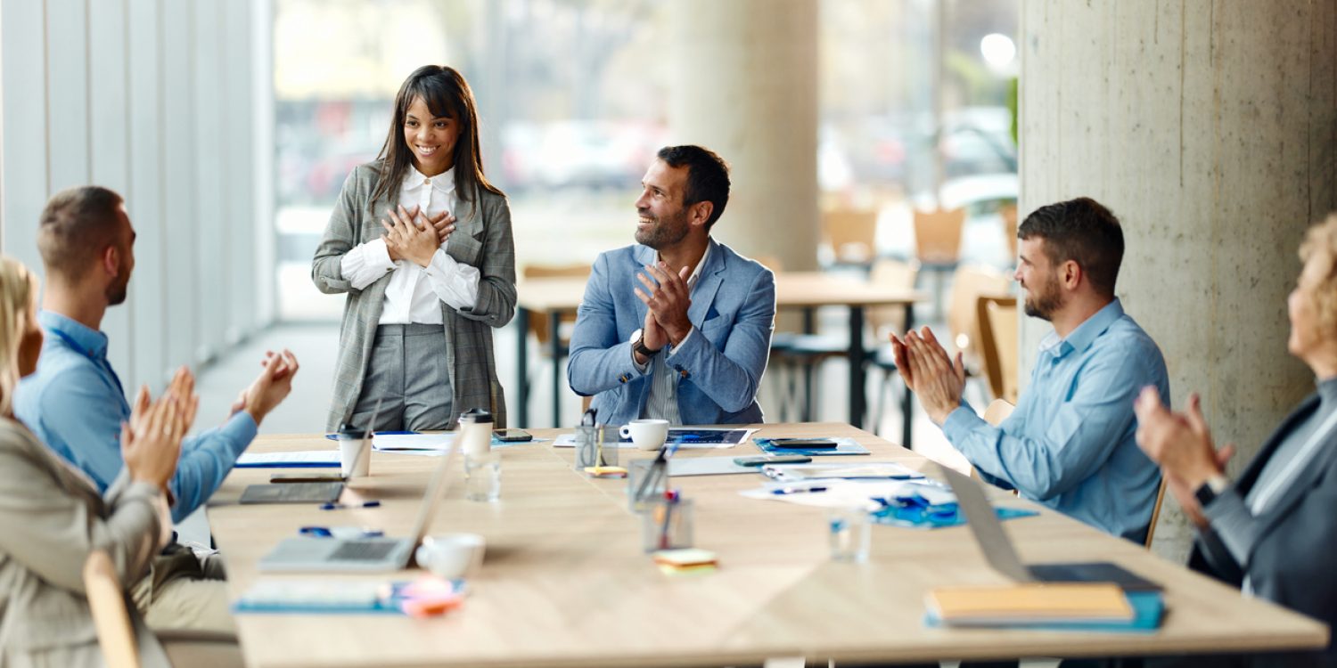 Happy female leader feeling grateful to her colleague who are congratulating her on successful meeting in the office.