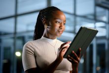 Tablet, office and black woman in business at night to research or review design for ads. Technology, online and creative brand consultant with campaign feedback or development on overtime in startup