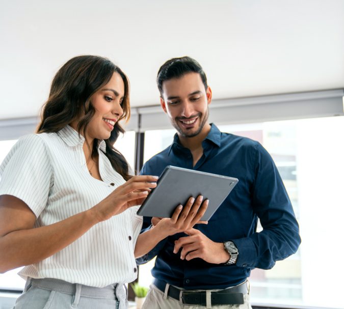 Latin American business people sharing ideas at the office while using a digital tablet - people at work concepts