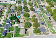 Suburban residential houses near Arbor Glen and Paige Road in The Colony suburb Dallas, Denton County, Texas, detached homes with solar roofing, lush green, swimming pool, large backyard, aerial. USA